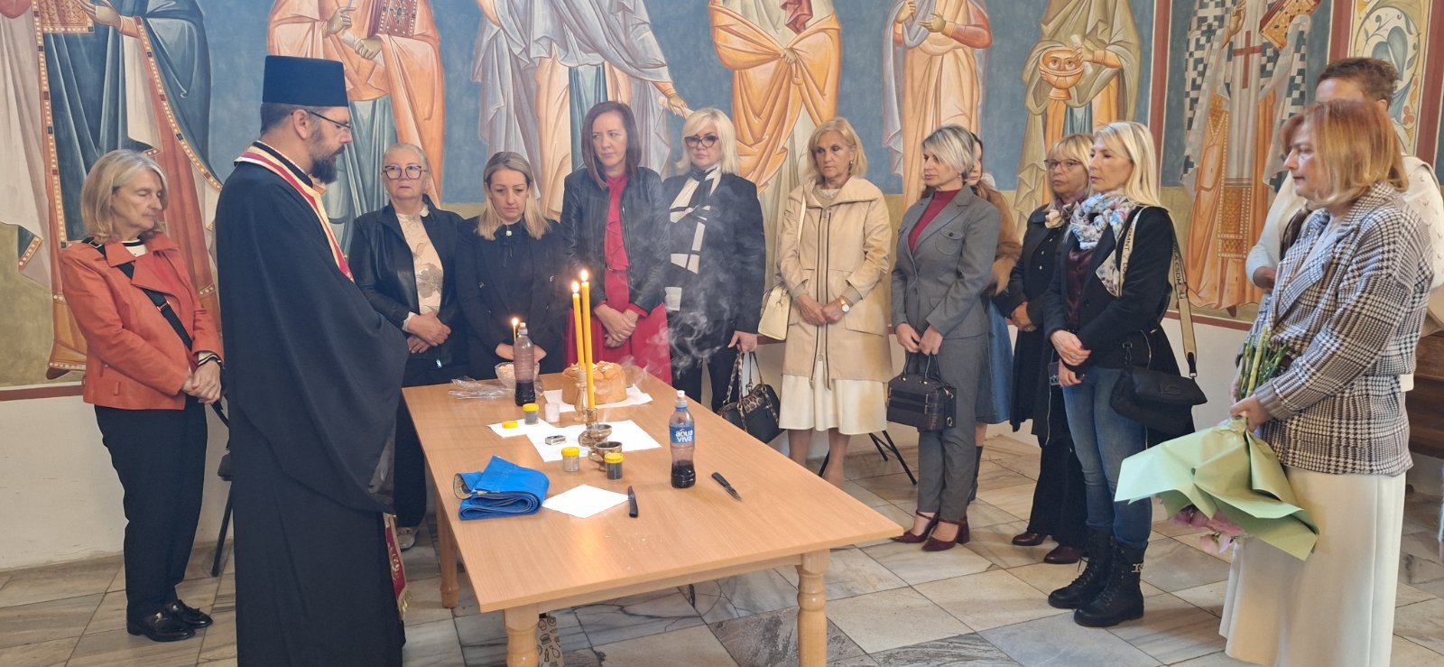 Sveštenik osvećuje slavski kolač u prisustvu članica Udruženja